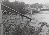 The angled girders disappear beneath the river