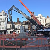 Demolition machinery looming over the ruins of the hotel